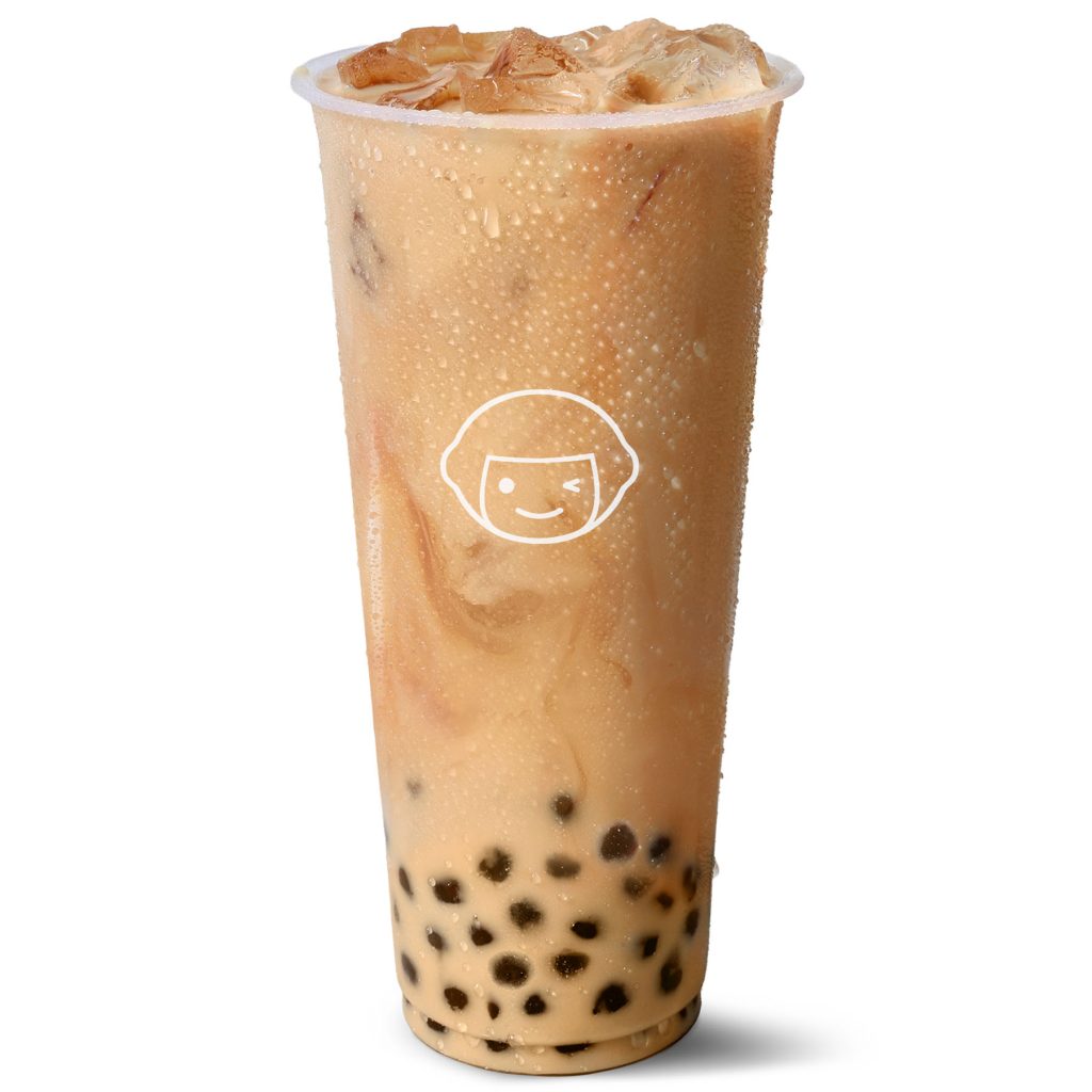 A clear plastic cup filled with iced milk tea and black tapioca pearls, showing condensation on the outside and a simple smiling face logo on the front.