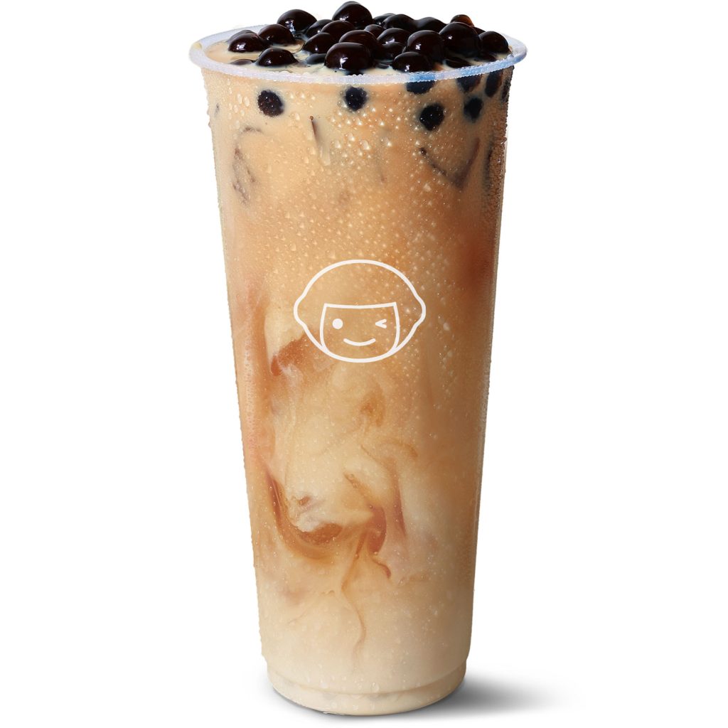 A clear plastic cup filled with iced milk tea topped with black tapioca pearls, featuring condensation on the outside and a simple smiling face logo printed on the front.