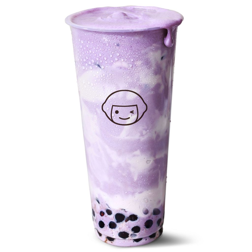 A tall plastic cup filled with a purple and white swirled bubble tea drink, topped with foam and condensation on the outside. Black tapioca pearls are visible at the bottom. A winking face logo is on the cup.