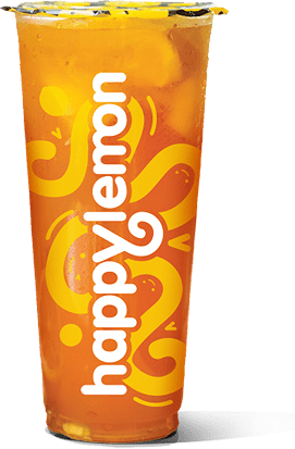 A clear plastic cup filled with an orange-colored iced drink and fruit pieces, featuring the "happylemon" logo and yellow abstract lemon designs on the cup.
